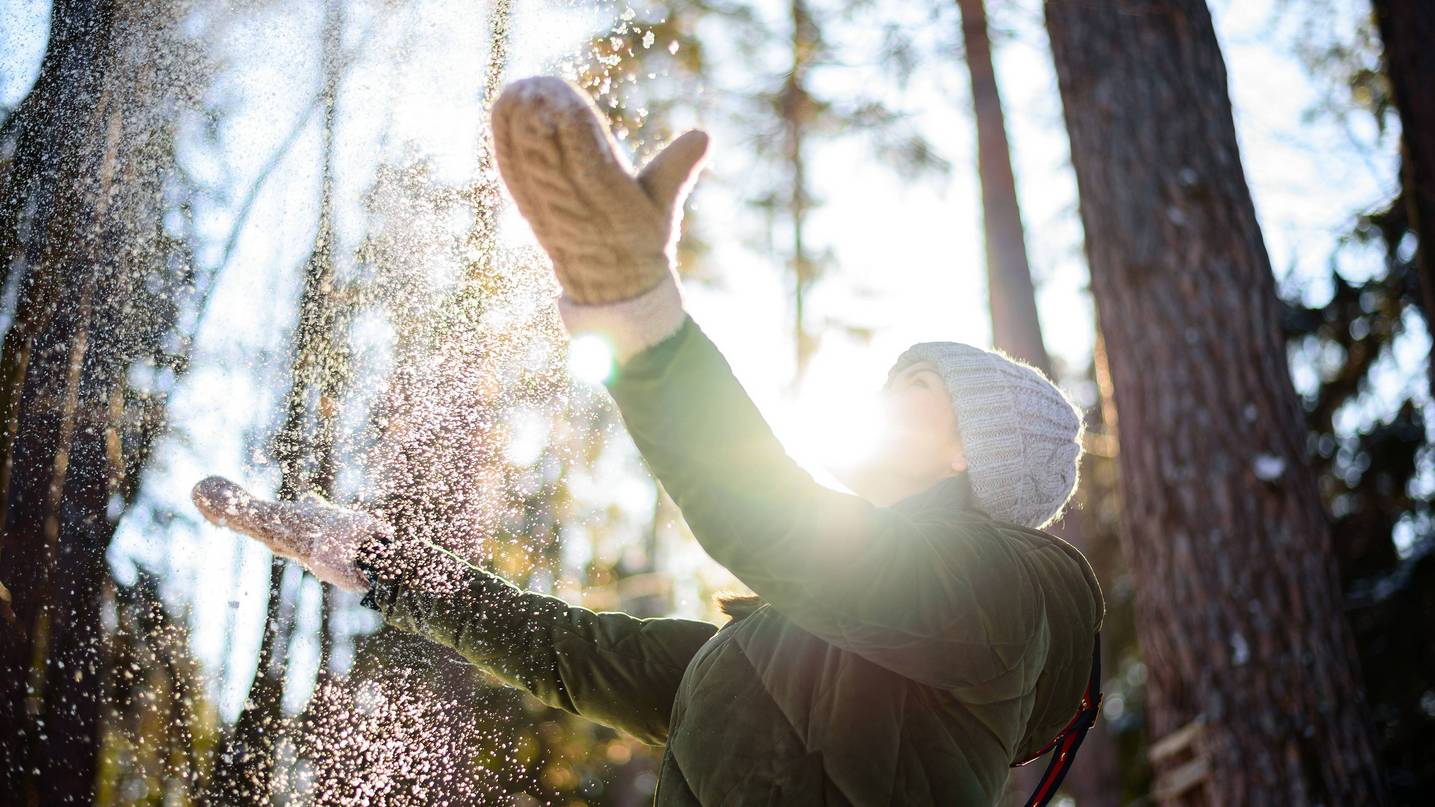 ©RuslanGallien/stock.adobe.com Frau im Winterwald und die Sonne scheint